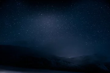 Fototapeten Schöner blauer dunkler Nachthimmel mit vielen Sternen über schneebedeckten Bergen © MagicalKrew