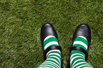 Woman standing on the grass and wearing Leprechaun's striped socks