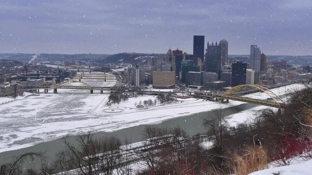 A real time, snowy establishing shot of downtown Pittsburgh, PA in the winter.  	