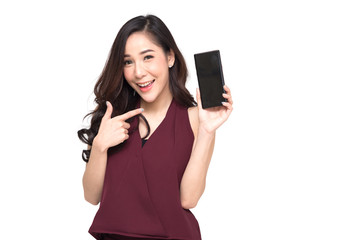 Fototapeta premium Portrait of a cheerful beautiful girl wearing red dress and showing or presenting mobile phone application and pointing finger to smartphone on hand isolated over white background, Asian Thai model