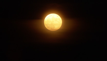 Yellow haze around full moon in dark sky