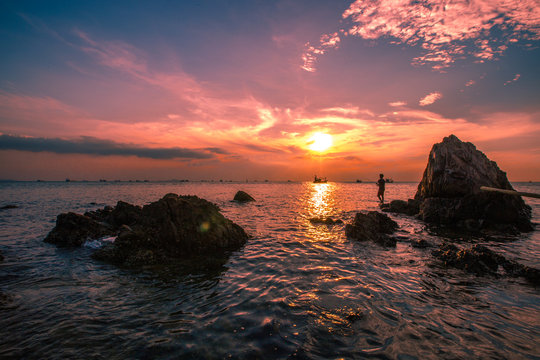 The background of the sea by the evening sea, with natural beauty (sea water, rocks, sky) and fishermen are fishing by the river bank, is a pleasure during travel. © bangprik