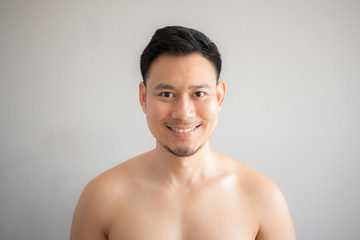 Smile Asian man in topless portrait isolated on gray background.