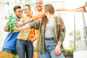 Happy friends cheering with beers in bar restaurant outdoor - Young people having fun drinking and toasting alcohol - Concept of youth friendship lifestyle