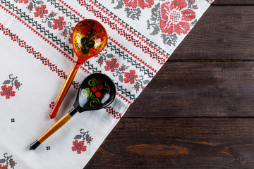 Khokhloma painting. Two wooden spoons with a traditional Russian pattern on a wooden background.