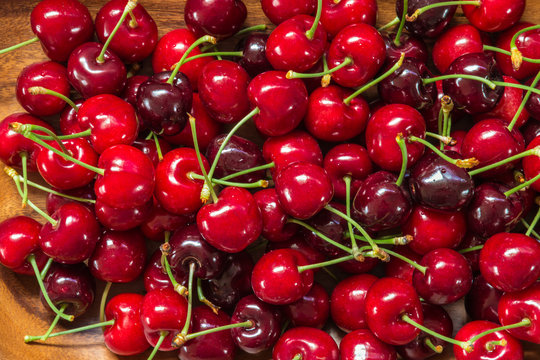 closeup of ripe red cherries in wooden bowl
