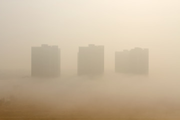 Environmental pollution concepts. Foggy buildings covered with ultrafine particles and smog.