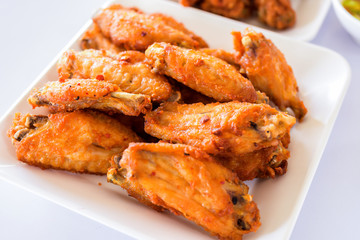 Thai style homemade fried chicken wings on white plate.A plate of fresh, hot, crispy fried chicken.
