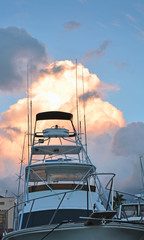 Looking up tall white tuna tower with long out riggers and antennas, on modern sport fishing boat...