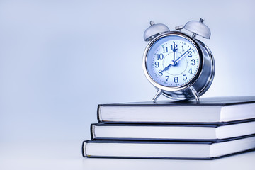 business, office, school and education concept. Alarm Clock On Books.