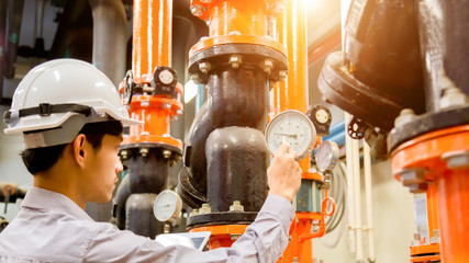 Asian engineer maintenance checking technical data of  system equipment Condenser Water pump and...