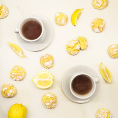 Lemon cookies isolated on white background. Homemade bakery products: stack of shortbread cookies with lemon flavor. Top view of a pile of lemon cookies on a white plate. Two cups of black tea.