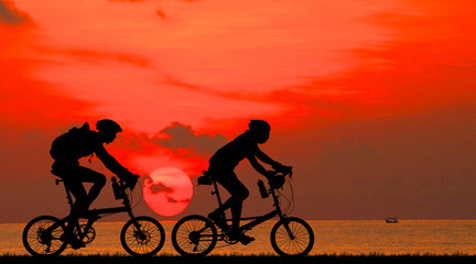 Obraz premium Silhouette group friend and bike relaxing on blurry sunset background.