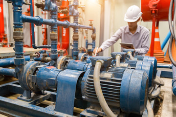 Asian engineer maintenance checking technical data of  system equipment Condenser Water pump and...