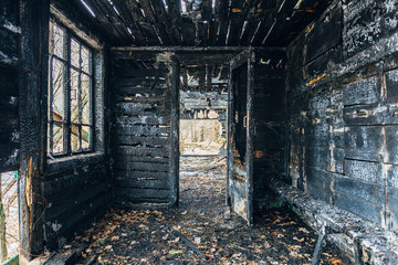 Fototapeta na wymiar Completely burnt wooden house. Consequences of fire