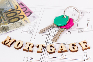 Inscription mortgage with keys and money on construction diagrams of house