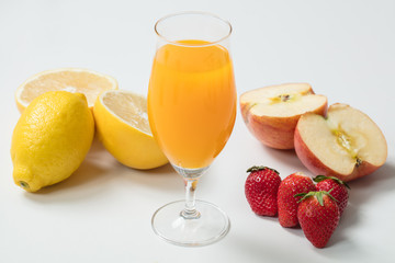 白背景にガラスに入ったフルーツジュースとフルーツ