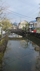 Canal in Kinosaki hot spring town, Japan. Along both sides of the canal are shops, ryokan and houses.