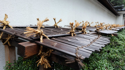 Roof made from bamboo sticks to protect garden shrubs from heavy snowfall in winter.