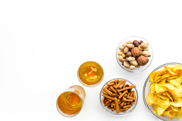 Snacks and beer. Chips, nuts, rusks near beer on white background top view copy space