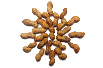 A collection of unrefined peanut nuts lie in the shape of a circle or sun on an isolated white background with a clipping path. Raw Peanut Pattern