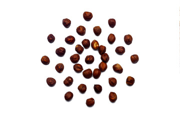 A collection of hazelnut nuts lie in the shape of a circle or sun on an isolated white background with a clipping path. Hazelnut pattern