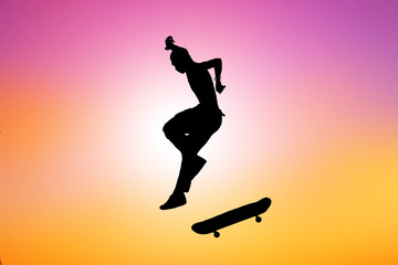 silhouette of skateboarder on blurry sunrise background.