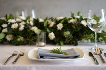Dining set on the white table sheet with white bouquet flower background