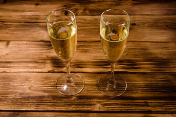 Two wineglasses with champagne on wooden table