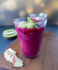 Glass of beetroot smoothie mix with apple, kiwi, chia seed and ice for detox and healthy drink on wood tray, black and white background.