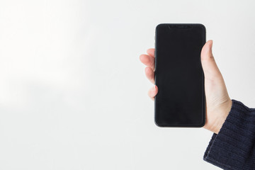 女性の手で片手でスマホを持つ白背景