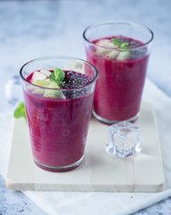 Glass of beetroot smoothie mix with apple, kiwi, chia seed and ice for detox and healthy drink on wood tray, black and white background.