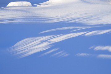Naklejka na ściany i meble Snowdrifts, illuminated by the sun, with deep blue shadows, beautiful winter landscape, 