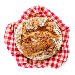Rustic   bread  isolated on  white background.  Whole Bread on a red checkered tablecloth close up. Bakery, food concept.