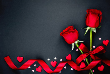 Beautiful valentines day background with red roses and hearts on black background. Flat lay, Copy space