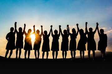 Silhouette of friends girls group celebrating at sunset, success concept