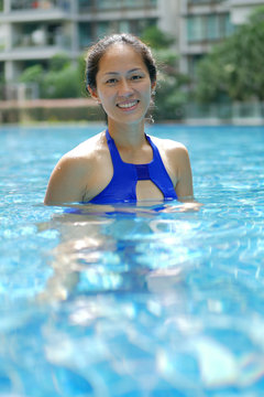 Asian Chinese Woman smiling confidently in swimming pool