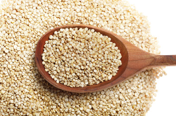 Raw organic superfood gluten free quinoa seeds in wooden spoon closeup on white background