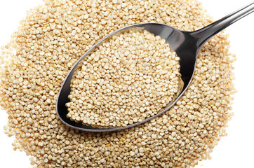 Raw organic superfood gluten free quinoa seeds in spoon closeup on white background