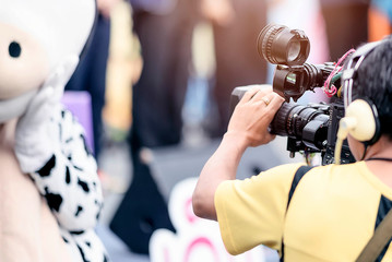 Video camera operator working with his equipment outdoor.