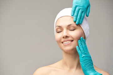 Derma rejuvenate treatment. Cosmetology face surgery. Anti wrinkle exam. Woman and doctor glove...