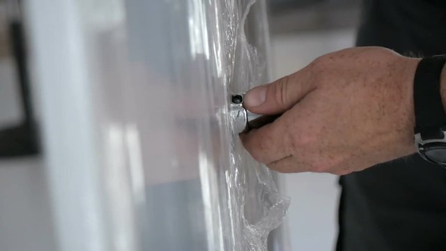 A hand of a furniture assembler with a screwdriver. Close up