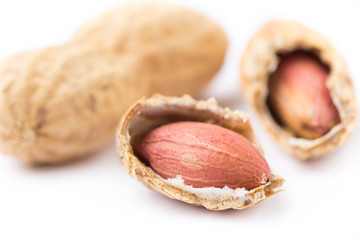 Close up of split peanuts in shell on white background. Healthy food, whole untreated nuts,...