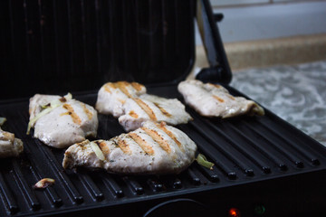 Fried meat on a electric grill in the kitchen 