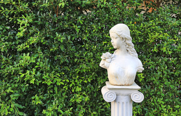 Woman statue in the garden with copy space. Wall leaf in nature park.