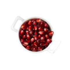 Pomegranate seeds in the white bowl isolated in white.