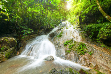 Beautiful waterfall in deep forest and soft water of the stream in the natural park, Thailand.