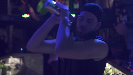 Joyful bartender mixes a cocktail in a shaker