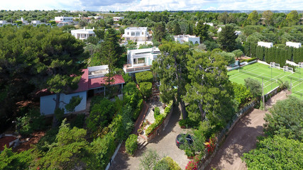 Fototapeta premium Beautiful drone view of harbor and beach side. Houses and buildings with solar panels built next to ocean or sea. Luxury lifestyle. Concept of travelling and summer holidays 