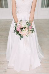 Fototapeta na wymiar Wedding bouquet of the bride in a bright Studio. Decor in the style of fine art.